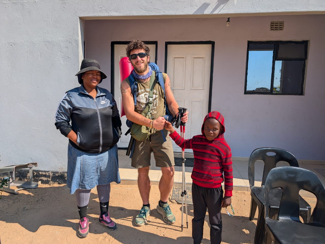 Campaign supporter meeting a child and community member outside a building