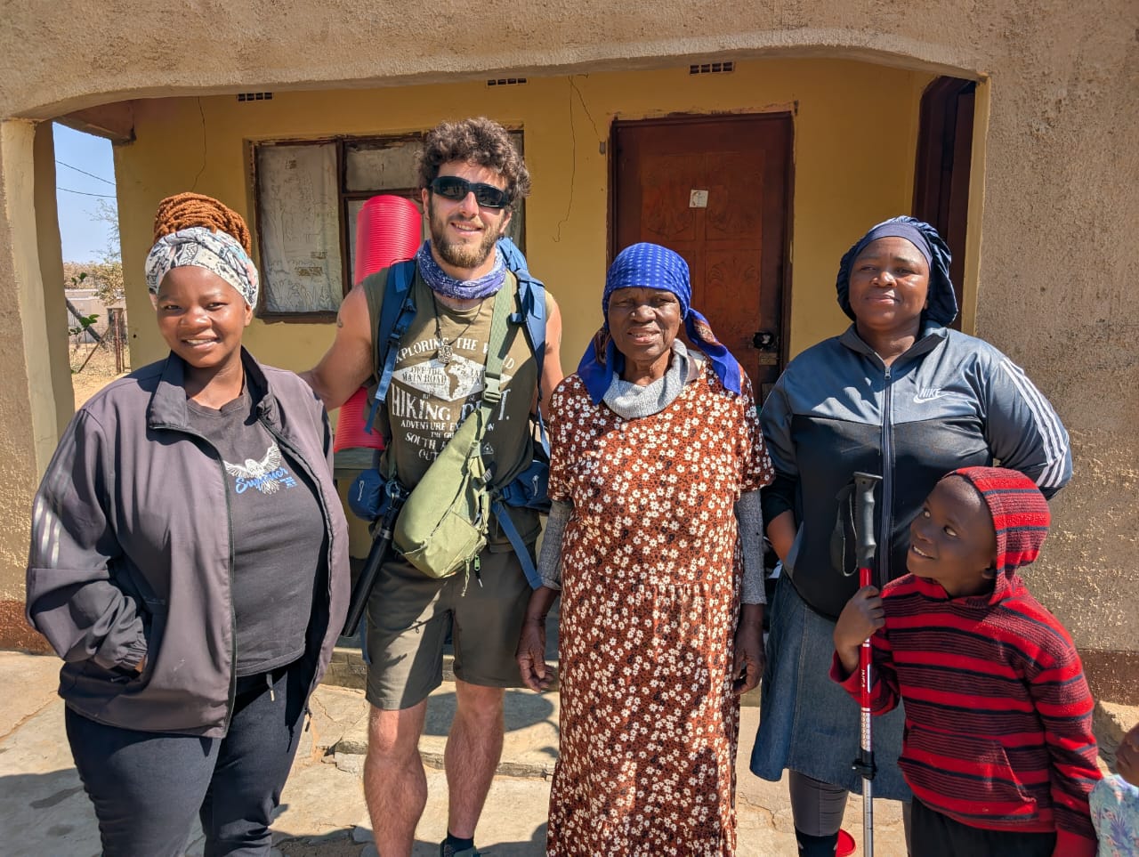 Álvaro de Miguel with community members outside a home